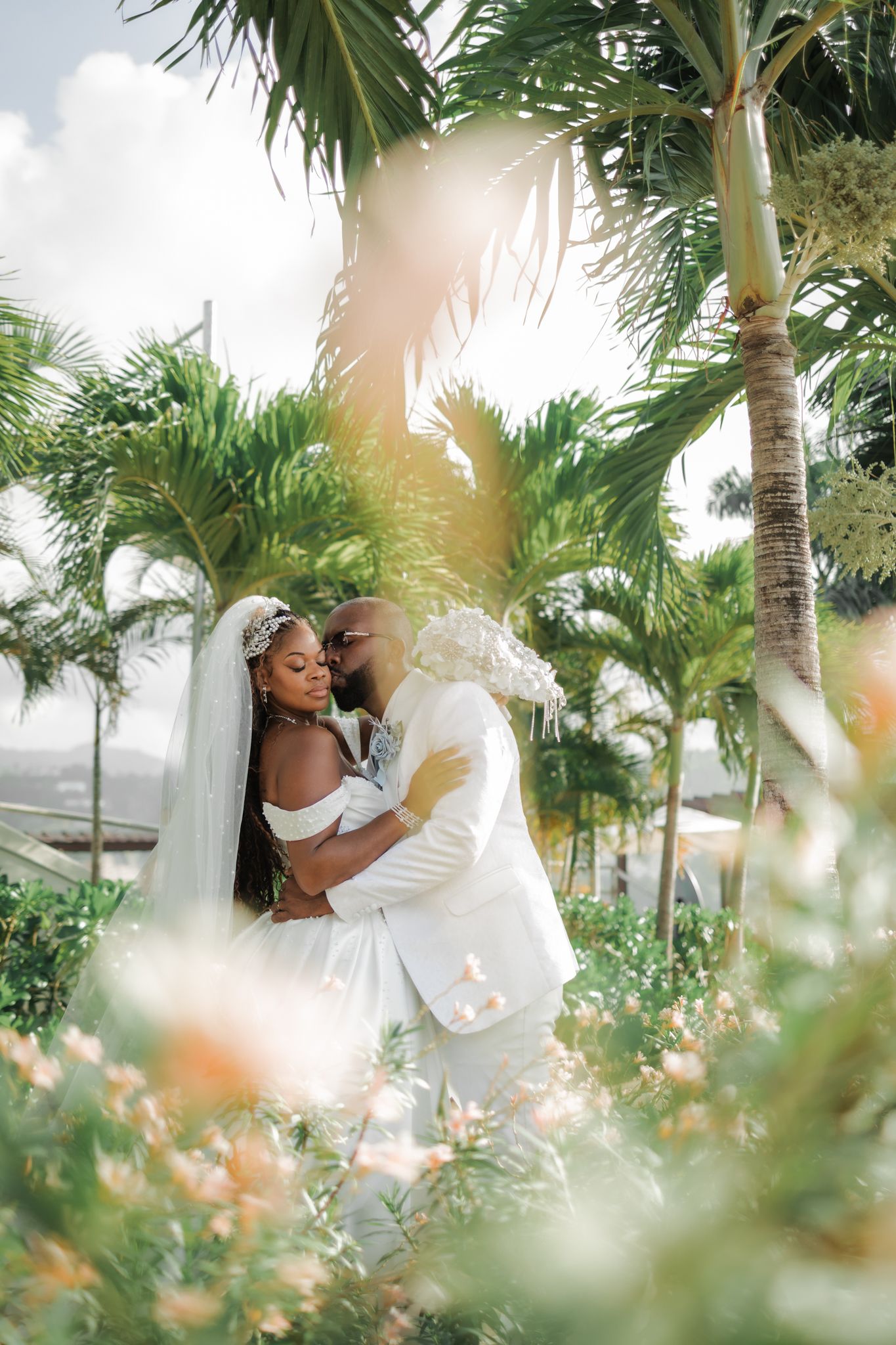 Bride and groom embracing among palm trees, Moon Palace Jamaica wedding photography